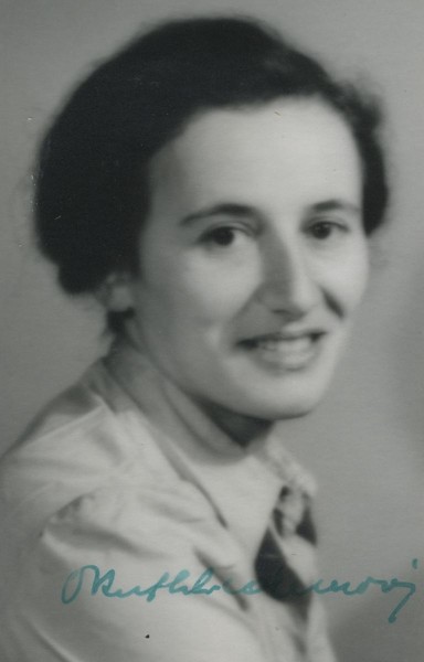 Black and white portrait of a smiling woman wearing a shirt and tie.