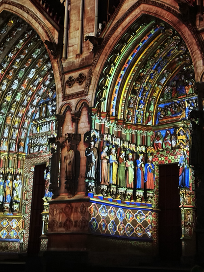 Color illuminated statues on Amiens Cathedral, striking bold primary colors