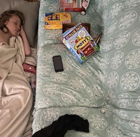 My type 1 diabetic son sleeping next to his low sugar emergency snacks and his dexcom, monopod