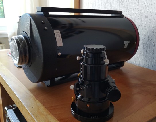 Ritchey-Chretien style telescope on a desk with the focuser detached to the side.