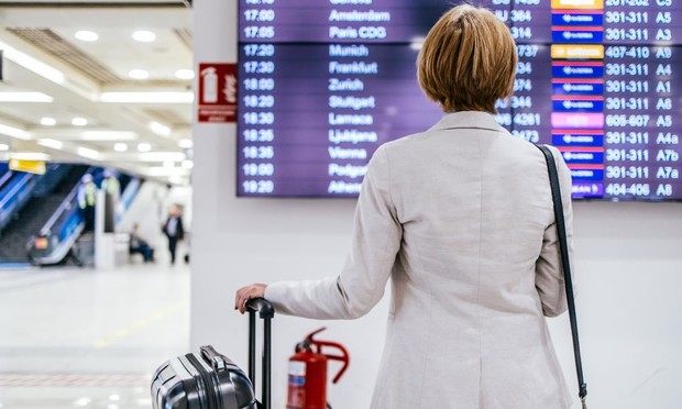 Una mujer mirando la pantalla de un aeropuerto. (Getty Images)