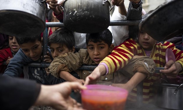 Niños palestinos esperan para recibir un poco de comida en Rafah, al sur de Gaza, el pasado 16 de febrero. (Fatima Shbair / AP)