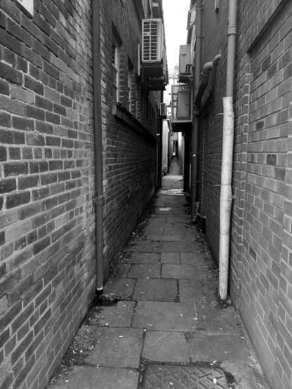 A Tight Squeeze for Monochrome Monday 

black and white photo of a very narrow alleyway studded with air conditioning units