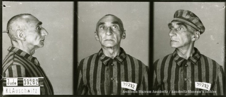 A mugshot registration photograph from Auschwitz. A man with a shaved head wearing a striped uniform photographed in three positions (profile and front with bare head and a photo with a slightly turned head with a hat on). The prisoner number is visible on a marking board on the left.