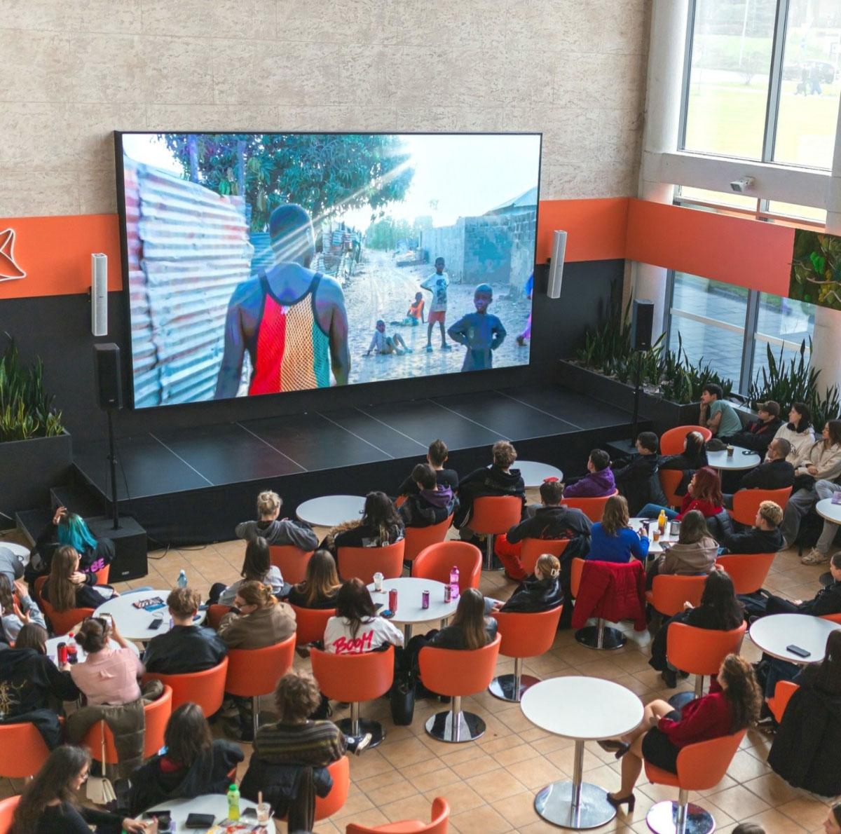 People watching an ethnographic film on a university campus.