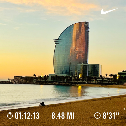 A golden sunrise over the W Hotel and the beach in Barcelona with running stats.