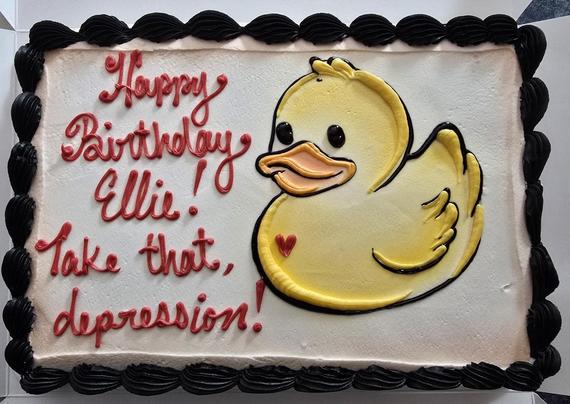 A birthday cake with Happy Birthday Ellie! Take that, depression. There is also a yellow duck.