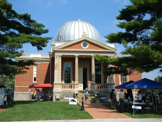 This image depicts a building with a prominent dome on top. The structure appears to be made of brick and has classical architectural elements, including columns. It is situated in a landscaped area with trees and tents set up, suggesting an event or gathering may be taking place outside. The atmosphere looks inviting, with blue skies in the background.

Image Credits: Wikimedia / Analogue Kid at en.wikipedia / CC BY 2.5