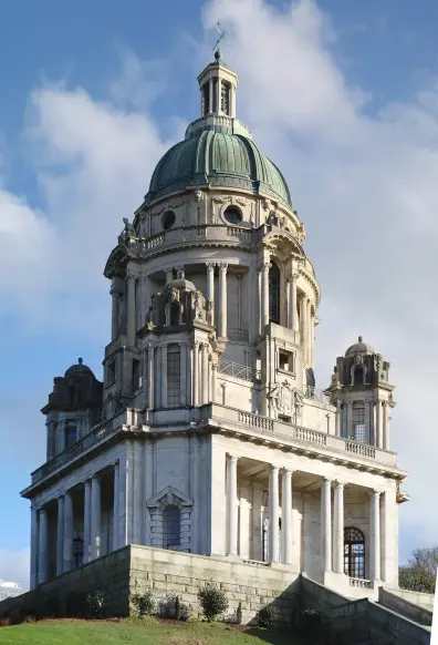 The image shows a large, architecturally impressive building with a prominent dome and several columns. The structure features classical styling with intricate details and is situated on a raised area, surrounded by green grass. The sky in the background is partly cloudy, contributing to a picturesque scene. Would you like to know more about this type of architecture or similar buildings?

Image Credits: Wikimedia / Mark Longair from London, United Kingdom / CC BY-SA 2.0