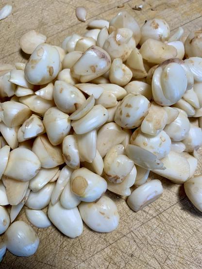 A close-up view of peeled jackfruit seeds scattered on a wooden surface.