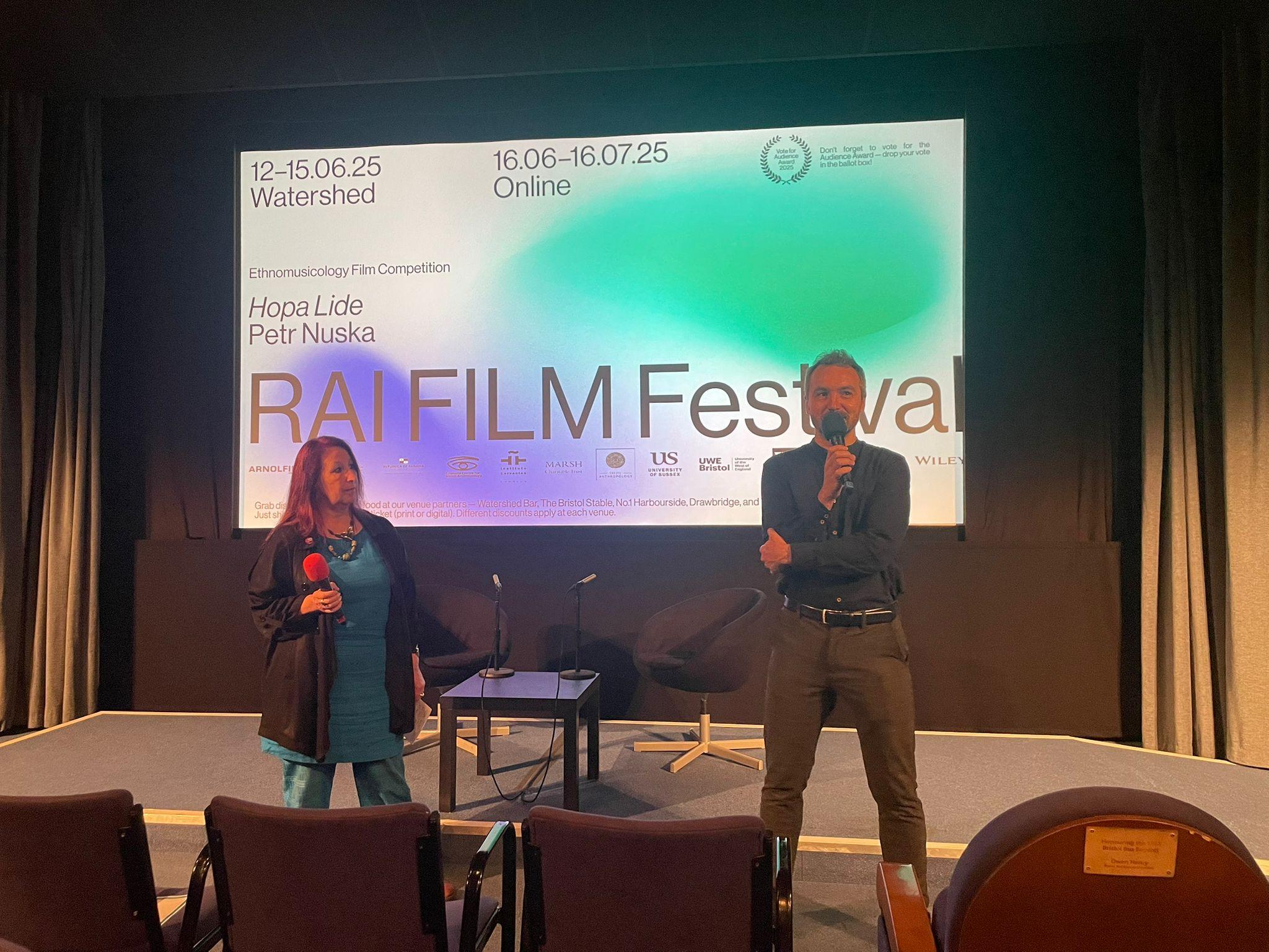 Two people – a woman and a man – in a cinema doing Q&A session. The screen behind them reads: "Hopa Lide, Petr Nuska, RAI FILM FESTIVAL"