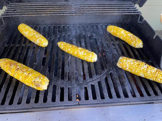 Five ears of corn on a barbecue grill 
