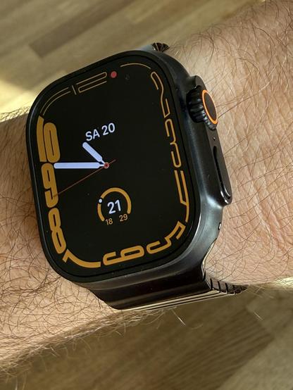 Apple Watch ultra 3 on my wrist. It has an orange ring on the digital crown which I matched with an orange watch face. 