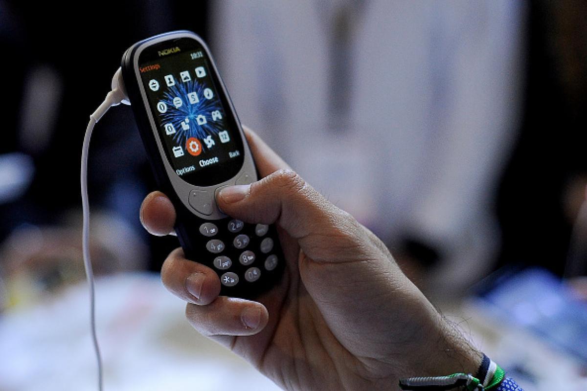 Imagen de archivo de una persona utilizando un antiguo móvil sin conexión a Internet. (Corbis via Getty Images)