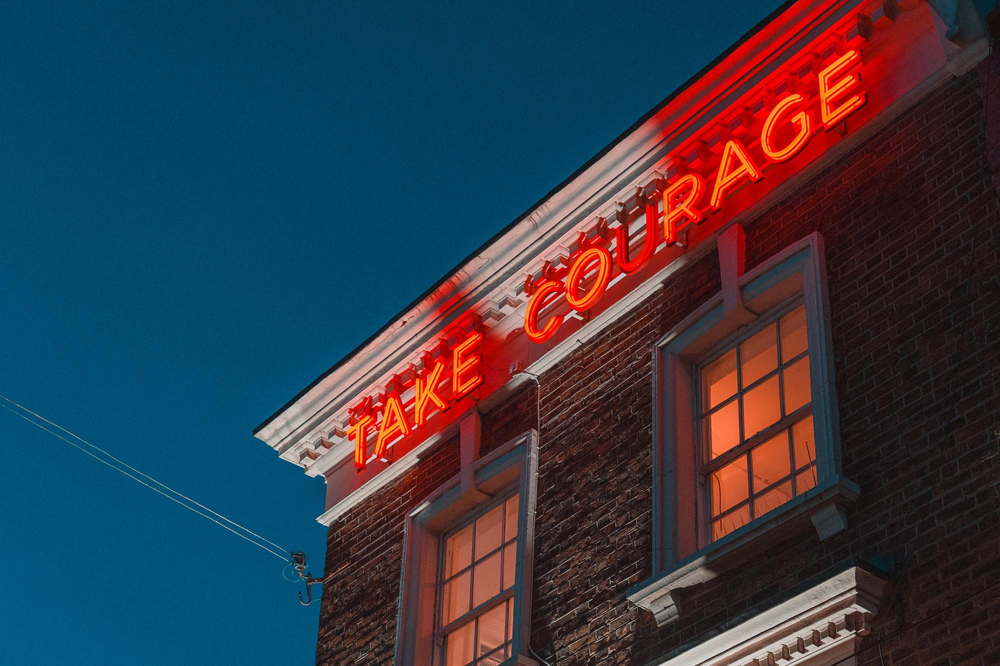 I took this photo somewhere in London. I believe my friend and I were walking around Camden market in the evening which is partly this cool mix of old brick buildings and trendy artsy stuff. So this photo shows the top of an old brick building, taken from the bottom. The sky is cler and blue and the top of the building has red glowing signage saying "TAKE COURAGE" in simple lettering. The windows underneath are glowing faintly red as well. I enjoy the colour, message and the diagonal line of the building through the horizontal framing of the image. I've been working with a particular colour treatment lately that makes reds and oranges glow in a particular way and I emphasises the blue of the sky a little to create a striking contrast. I quite enjoy this one.