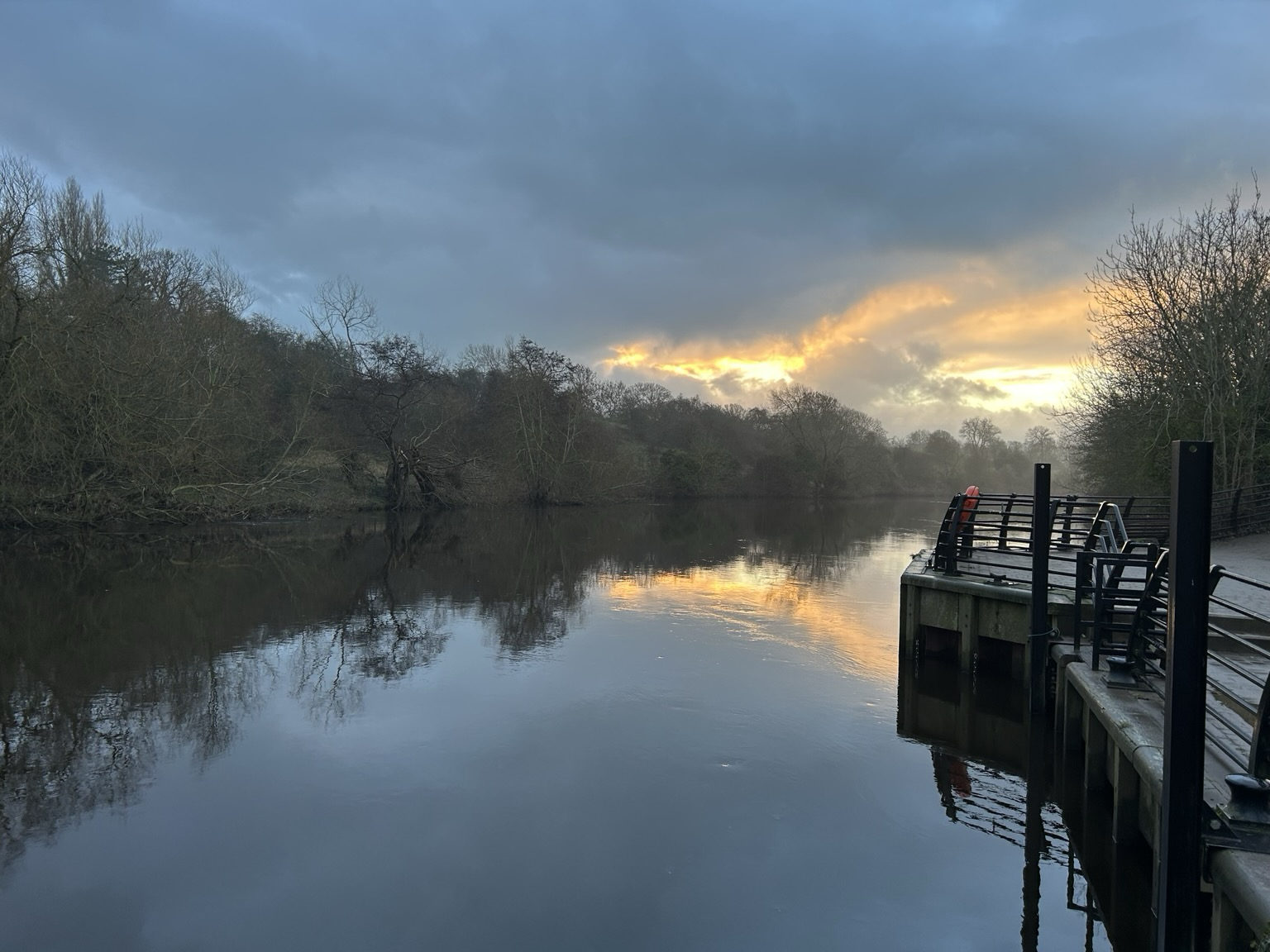 Looking downstream from Yarm Wharf towards Preston Park. Cloudy skies with some golden sunlight just emerging.