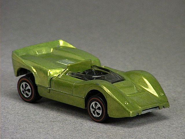 Released in 1969, Spectraflame Olive Mclaren MGA of 1969 Grand Prix with Redline wheels. Notes: Back lifts up to reveal a metal engine. HK casting has flatter tail lights, less defined door lines and does not have fender vents. Packaging: Grand Prix. Metal Body, Metal Base. Made in Hong Kong. Scarcity: 4/10