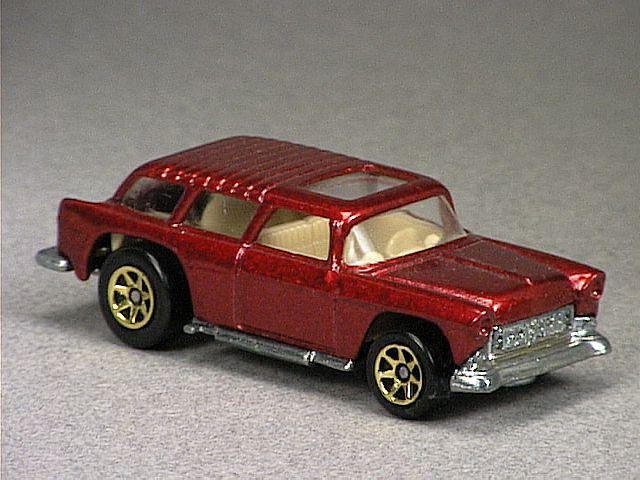 Released in 1996, Metal Flake Red Chevy Nomad of 1996 with Gold 7-Spoke wheels. Tampo: Hot Wheels logo gold rear door; with open steering wheel. Packaging: Blister Card. Metal Body, Metal Base. Made in Malaysia. Scarcity: 2/10