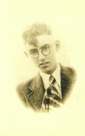 Vintage photograph of a young man wearing round glasses and a suit with a tie.