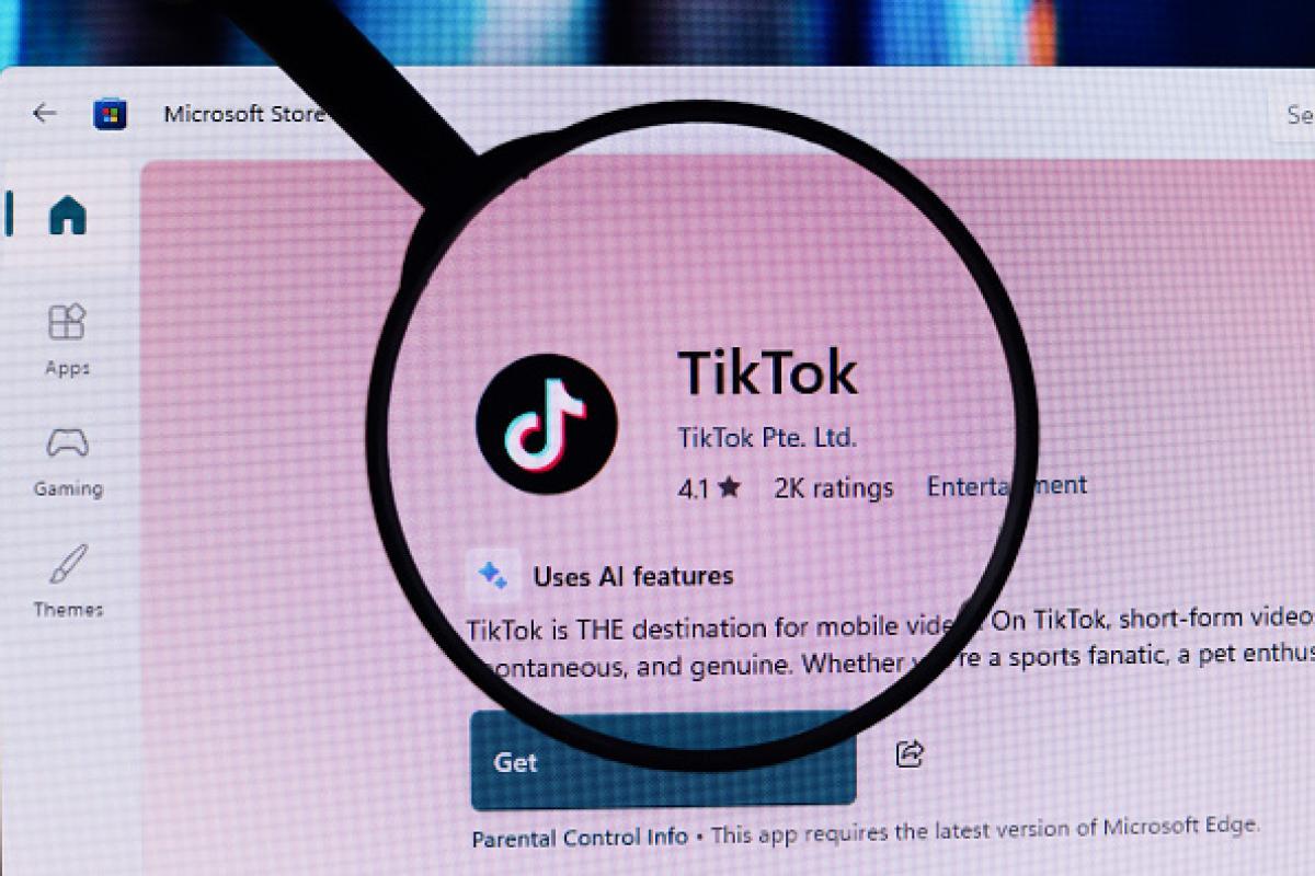 Montaje con una lupa sobre el logo de TikTok. (NurPhoto via Getty Images)