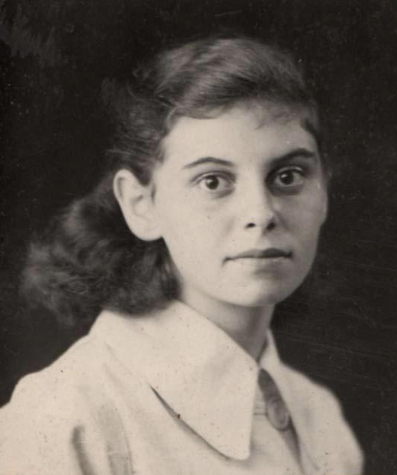 Portrait of a girl with a serious expression, wearing a light-colored collared shirt.