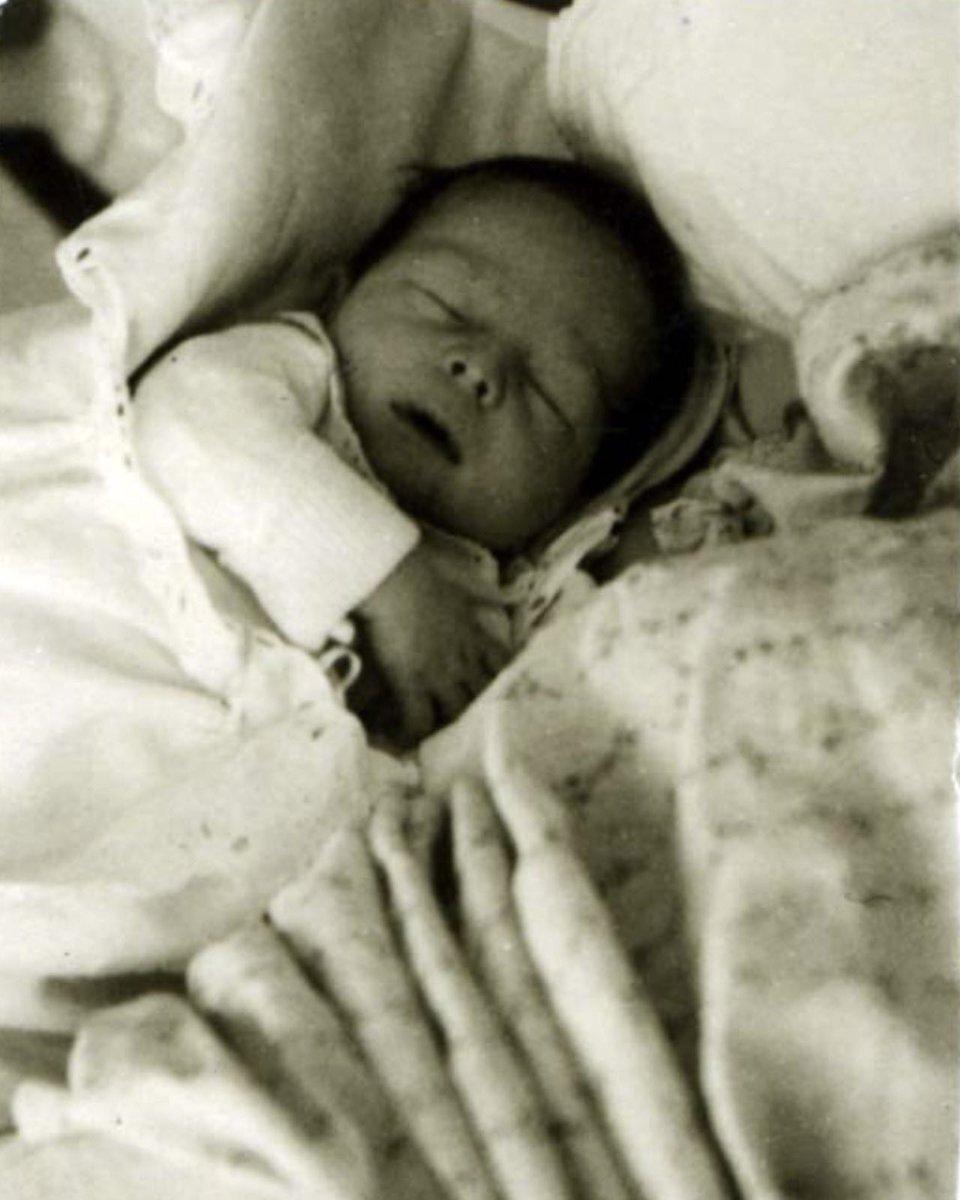 Newborn baby sleeping peacefully, swaddled in soft blankets.