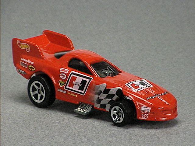 Released in 1997, Red Firebird Funny Car of Kmart Funny Car Racing Team Set with 5-Spoke wheels. Notes: New 1996 version. Tampo: Black/silver checker flag, white/black Hurst logo, yellow/white/black racing logos. Packaging: Four-car window box with three figures. Metal Body, Metal Base. Made in Malaysia. Scarcity: 2/10
