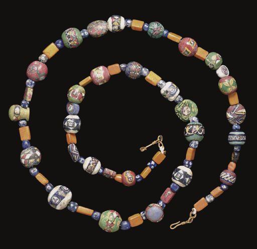 Roman mosaic glass bead necklace, dated circa 1st Century CE

Composed of thirty-two beads in bright colours ~ spherical, disc-shaped, rectangular and drop-shaped, seventeen with faces, three encircled by lotus flowers, two with petalled flowers, two with Nilotic birds in profile, one millefiori bead, and eight with geometric designs, on a green, white, red or blue ground, interspersed with rectangular opaque orange glass beads and small, spherical blue and white millefiori beads

The necklace measures 82cm long and has been restrung with a modern hook-and-loop closure

Sold at auction by Christies, December 2007