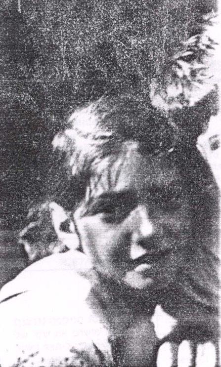 Black and white grainy image of a young girl with a focused expression.