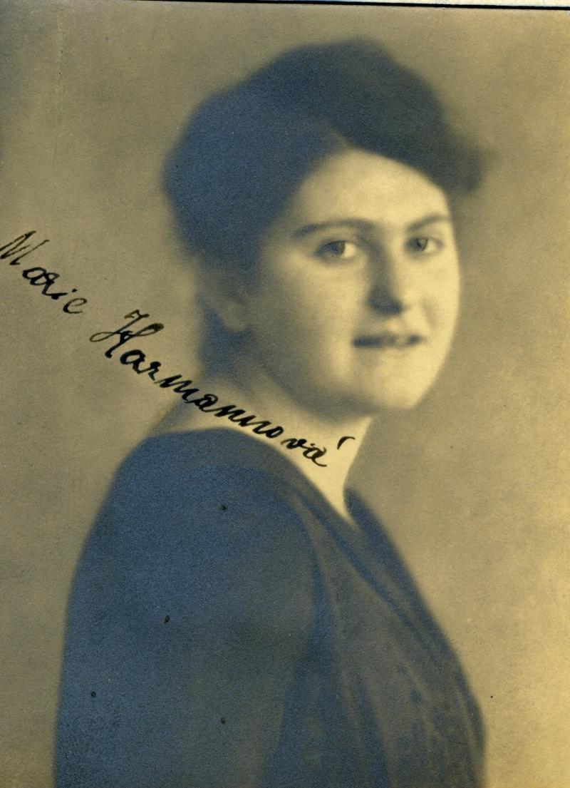 Vintage portrait of a woman, facing right with a gentle expression, wearing a dark blouse.