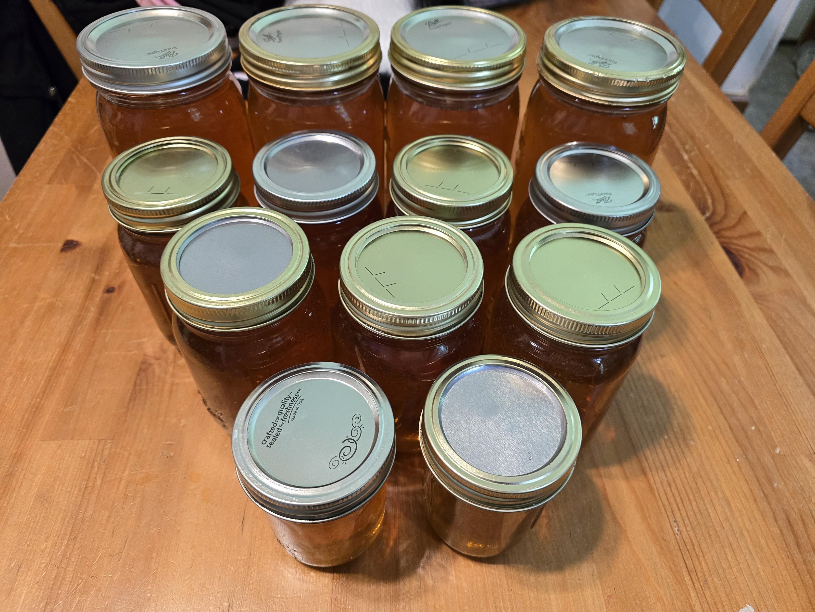 A mix of jars sizes of raw honey in a glass jar. It's golden yellow and tastes of basswood and wildflowers.