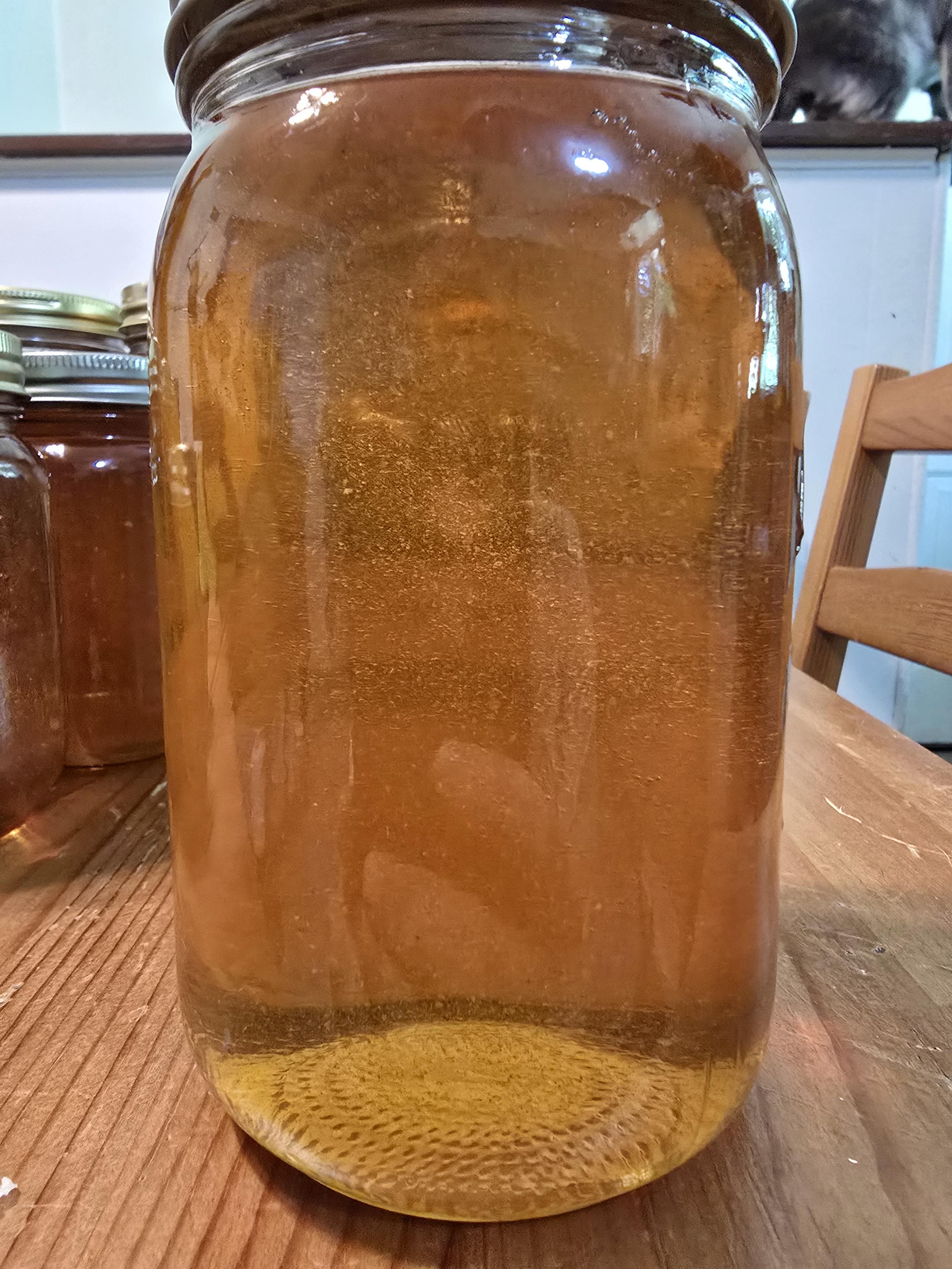 A single quart of raw honey in a glass jar. It's golden yellow and tastes of basswood and wildflowers.