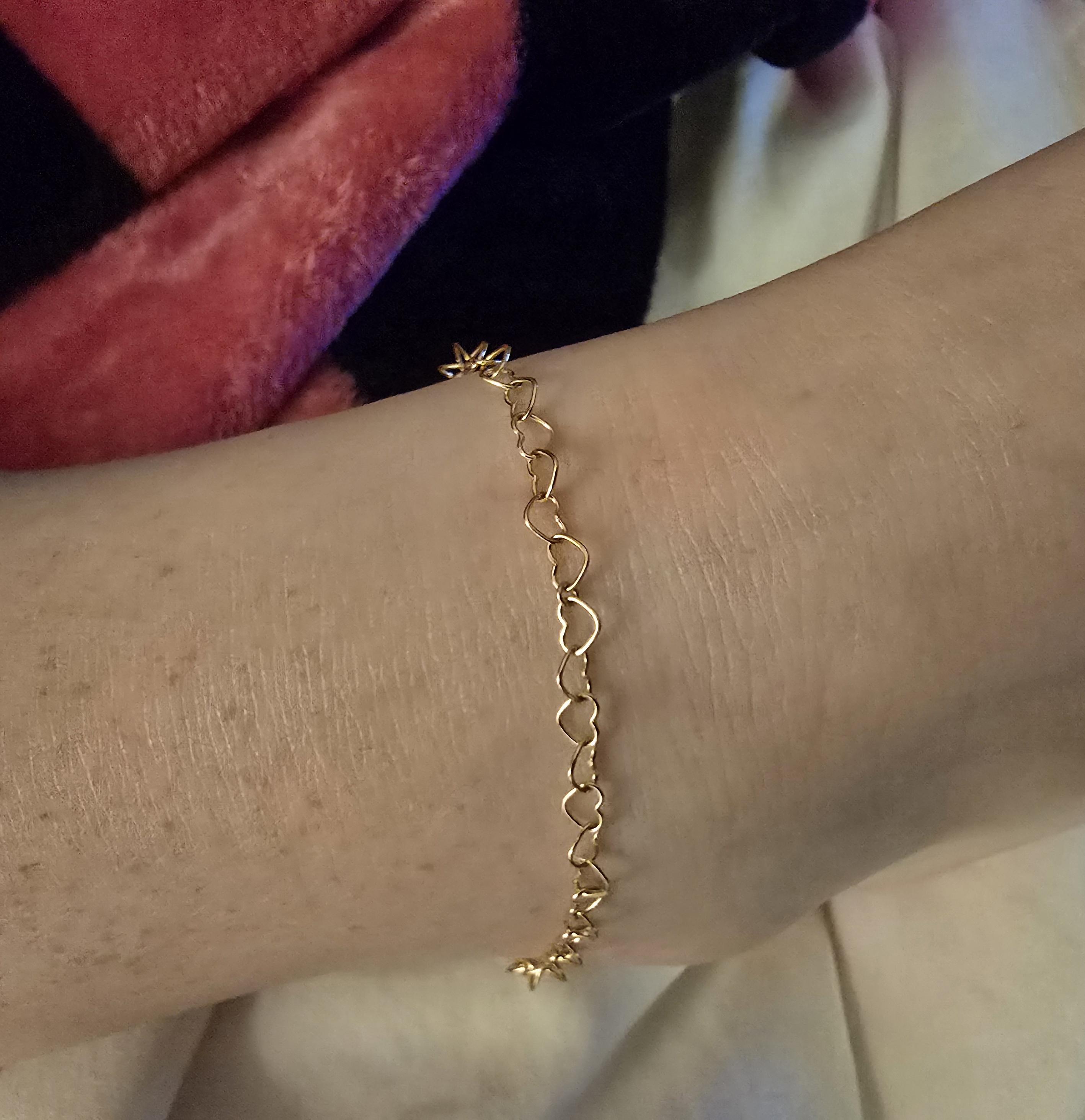 A gold heart link anklet on Ellie. It's welded on.