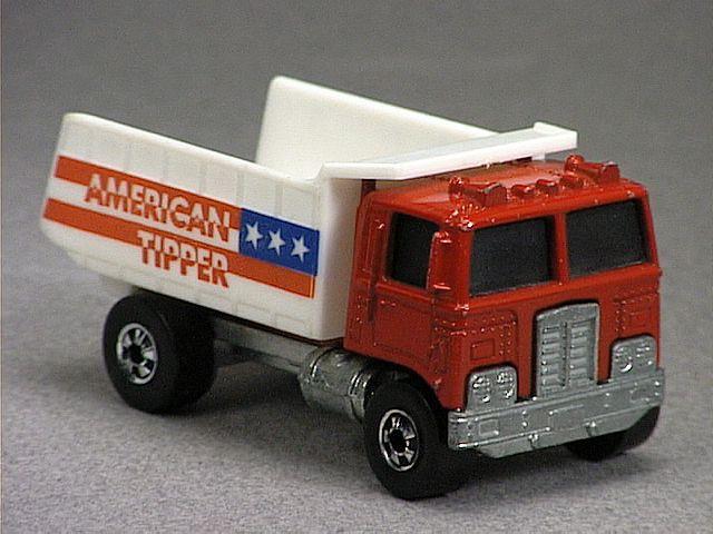 Released in 1976, Red American Tipper of 1976 Hot Wheels with Redline wheels. Notes: Based on a Dump Truck with a white plastic dumper. Tampo: Red and blue 'American Tipper' and 3 stars and stripes on sides of dumper. Packaging: 1975 Blister. Metal Body, Metal Base. Made in Hong Kong. Scarcity: 4/10