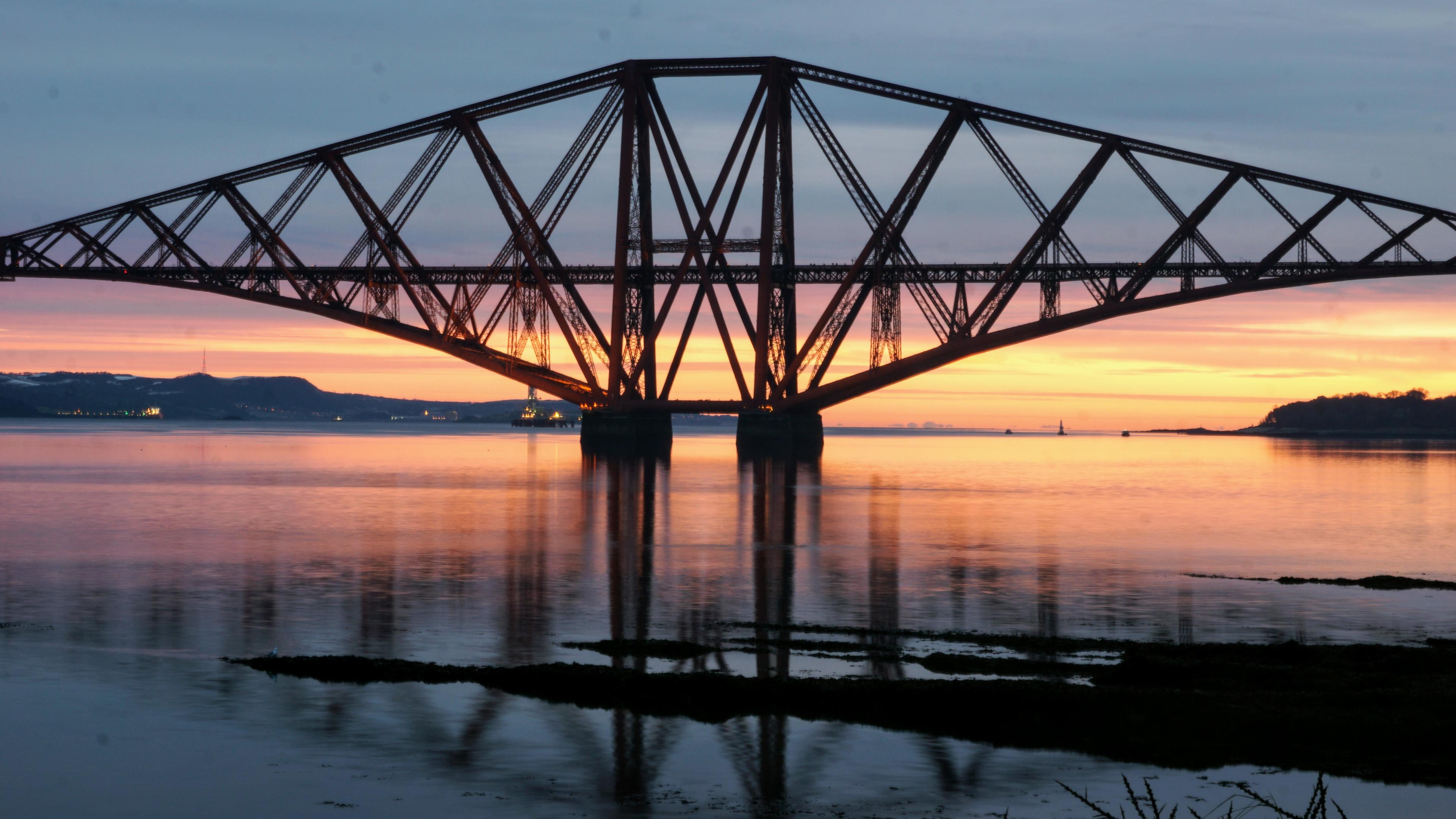 A bridge with the sun coming up behind