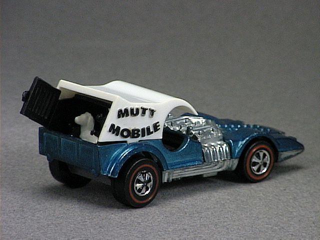 Released in 1971, Spectraflame Light Blue Mutt Mobile of 1971 Hot Wheels with Redline wheels. Notes: White plastic top, two white plastic dogs in rear. Tampo: Blue 'Mutt Mobile' imprinted on sides. Packaging: 1971 Blister. Metal Body, Metal Base. Made in Hong Kong. Scarcity: 8-9/10