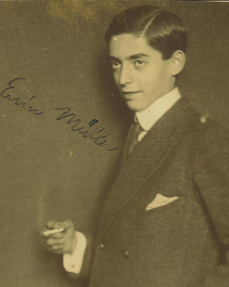 Vintage portrait of a man posing in a suit and tie with a handkerchief in the pocket, holding a cigarette
