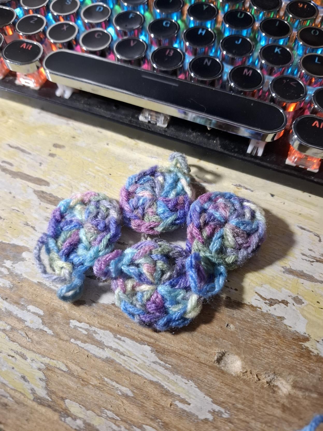 Variegated purple yarn crocheted into tiny circles. The base of the African Flower.