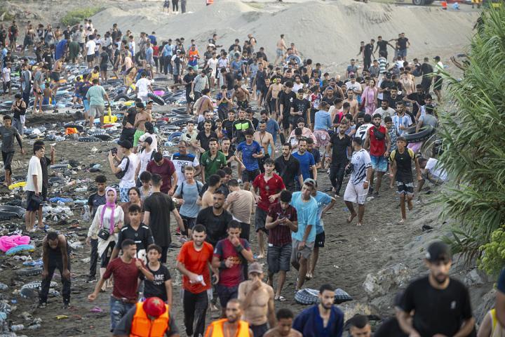 Un grupo de personas camina hacia el casco urbano de Ceuta, tras cruzar desde Marruecos por la zona del Tarajal, el 30 de julio de 2026. (Marcos Moreno / Anadolu via Getty Images)