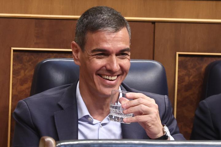 El presidente del Gobierno, Pedro Sánchez, riéndose en el Congreso, con un vaso de agua en la mano. (Europa Press News)