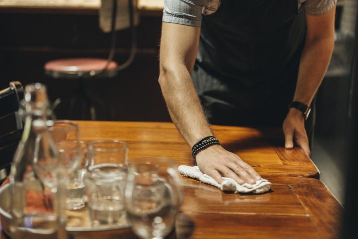 Un camarero limpia la mesa de un bar. (Getty Images)