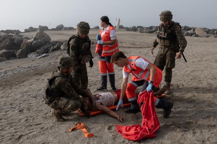 Sid Ahmed Dib, argelino de 23 años, es ayudado por soldados españoles y la Cruz Roja, tras cruzar a nado la frontera hasta la playa de El Tarajal (Ceuta). (James Breeden/Getty Images)