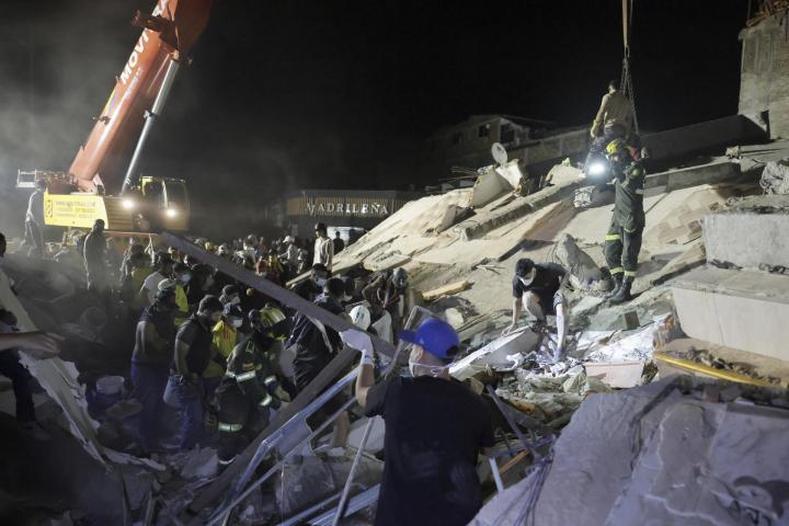 Integrantes de la Policía de Búsqueda y Rescate y vecinos quitan escombros en un edificio hundido por el terremoto en Pereira (Colombia), el 11 de agosto de 2026. (Carlos Ortega / EFE)