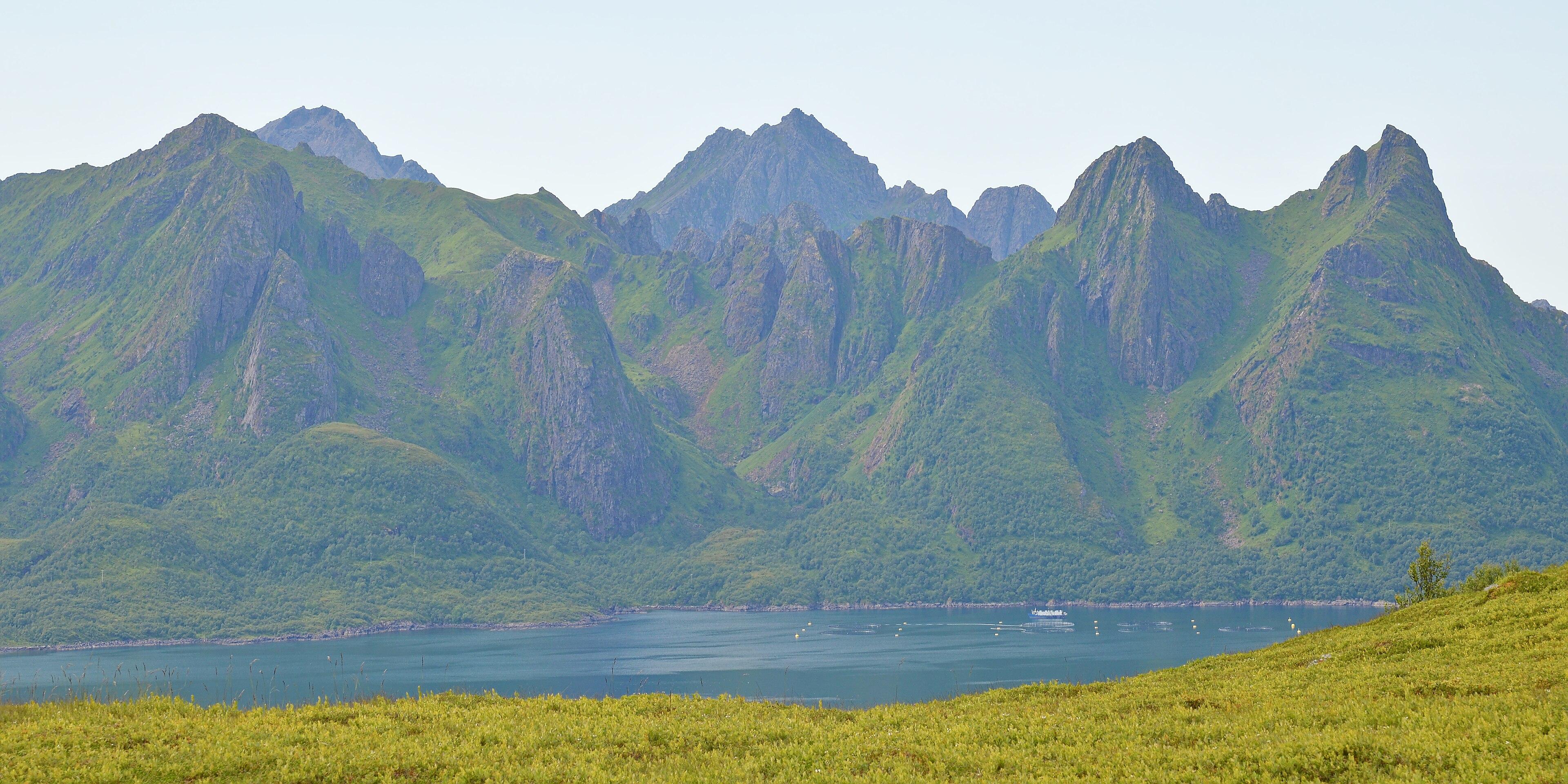 A photo of a jagged mountainous island. The sky is hazy..