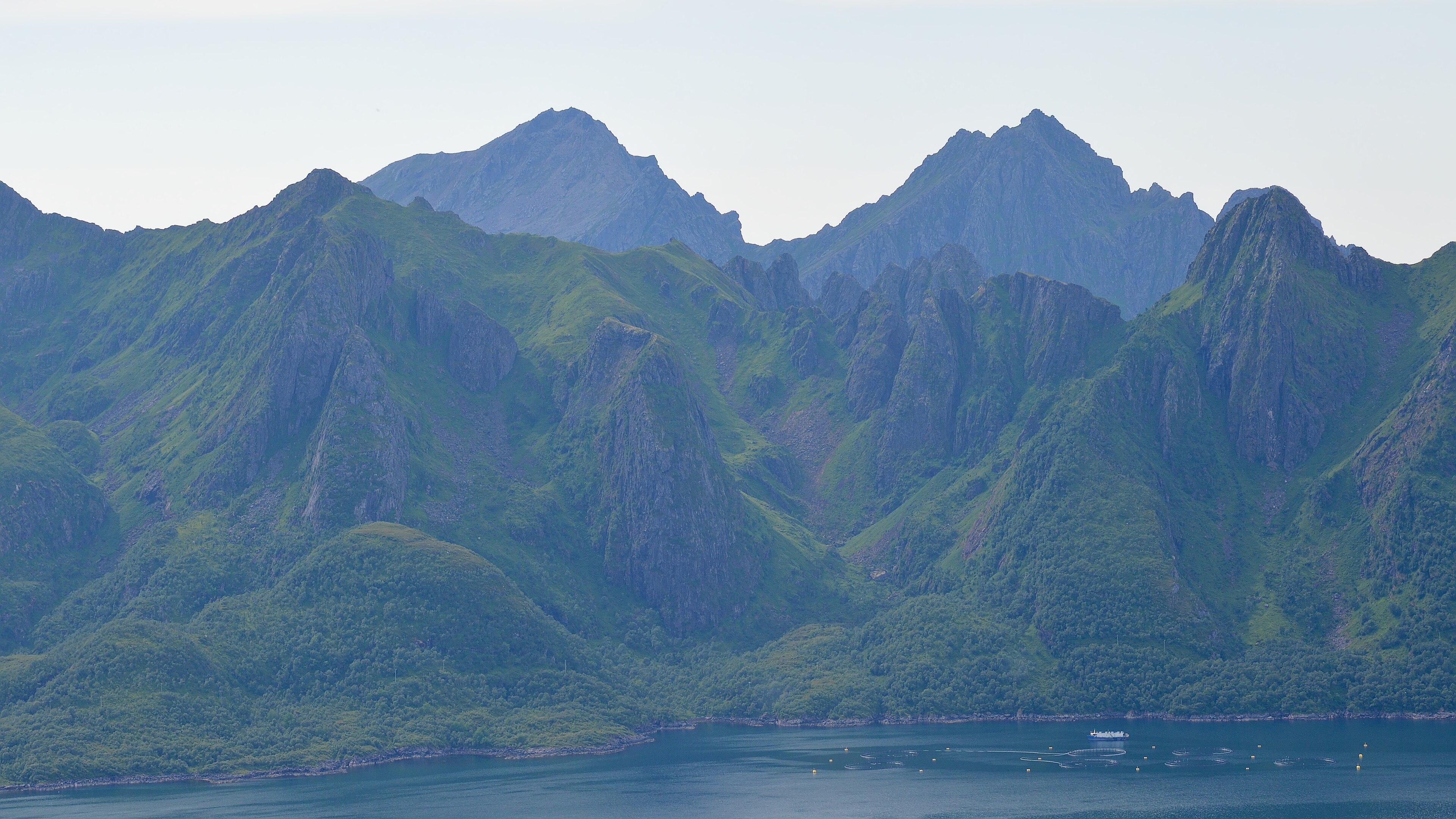 A photo of a jagged mountainous island. The sky is hazy..