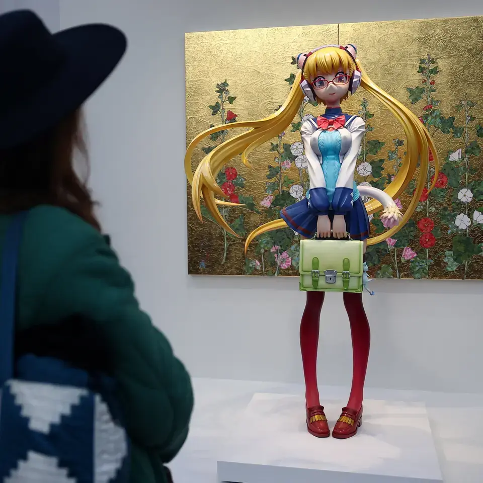 Eine Person betrachtet eine lebensgroße Skulptur mit dem Titel "School Girl Ko²" (2023–2026) von Takashi Murakami.