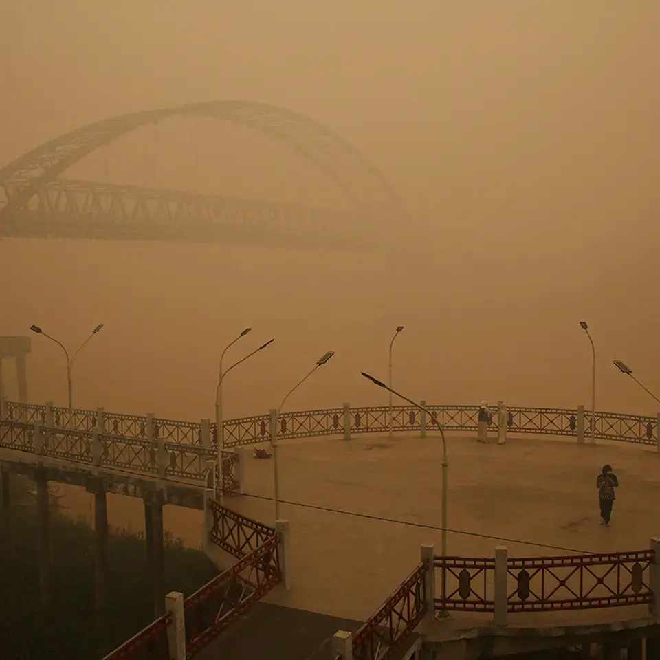 Eine Person geht an einer Promenade entlang, während starken Rauchnebel am Ufer des Kahayan-Flusses in Palangka Raya, Indonesien