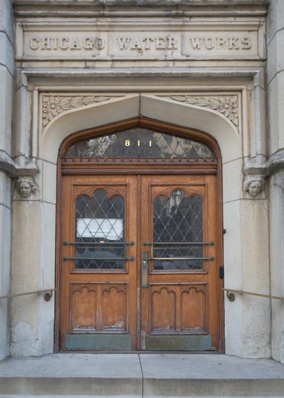 Pair of stained wood doors surrounded by limestone at the Chicago Water Tower.