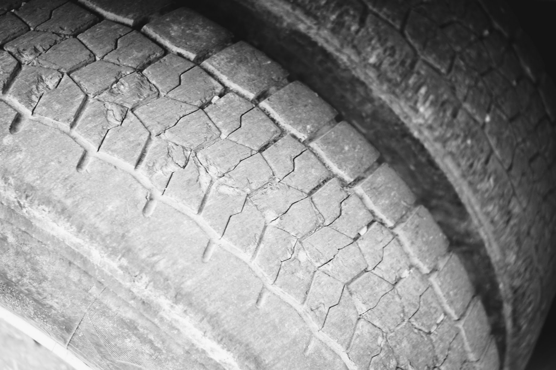 two worn lorry tyres with stones between the treads