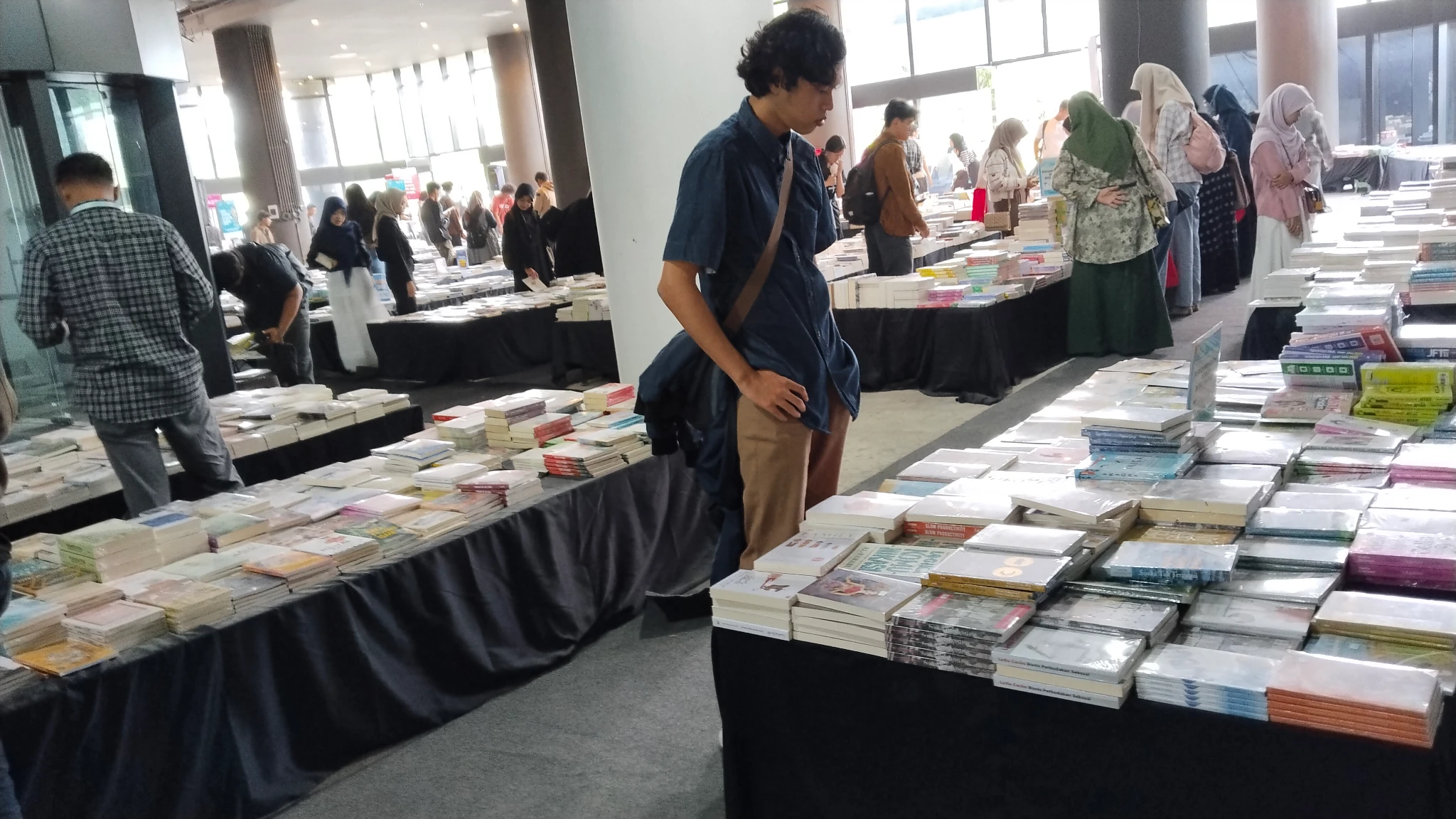 Beberapa orang menunduk melihat tumpukan buku